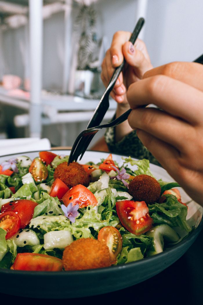 A vibrant and fresh vegetable salad with tomatoes, lettuce, and crispy falafel, perfect for a healthy meal.